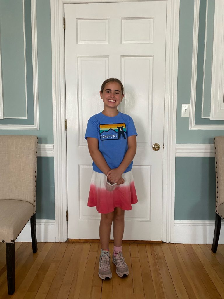 Young girl smiling standing in front of door